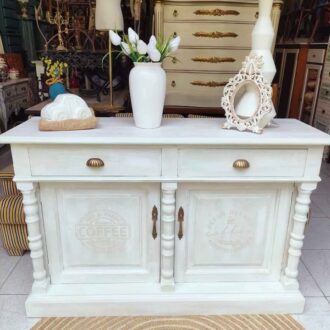 APARADOR VINTAGE CON MOTIVOS DE CAFÉ 5 Precioso aparador de madera estilo vintage, pintado y decapado en tonos azul, beige y blanco. Decorado con delicados motivos de café, combina elegancia clásica con encanto artesanal. Cuenta con dos cajones y dos puertas, perfecto para cualquier estancia del hogar.