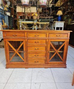 Aparador rustico de pino macizo con vitrinas laterales y múltiples cajones.