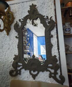 Espejo antiguo con marco de metal envejecido.