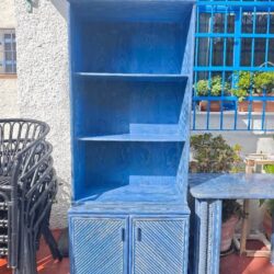 Blue wooden bookshelf with open shelves and decorative doors.