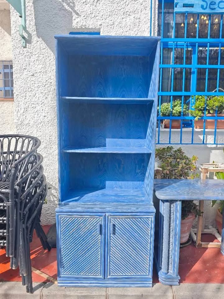 Estantería azul con puertas 1 Estantería azul de madera con baldas abiertas y puertas decorativas.
