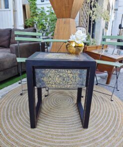 Mesita auxiliar Mandala – Mesa auxiliar decorativa en madera negra con detalles dorados pintados a mano. Medidas: 50 cm ancho × 40 cm fondo × 61 cm altura.