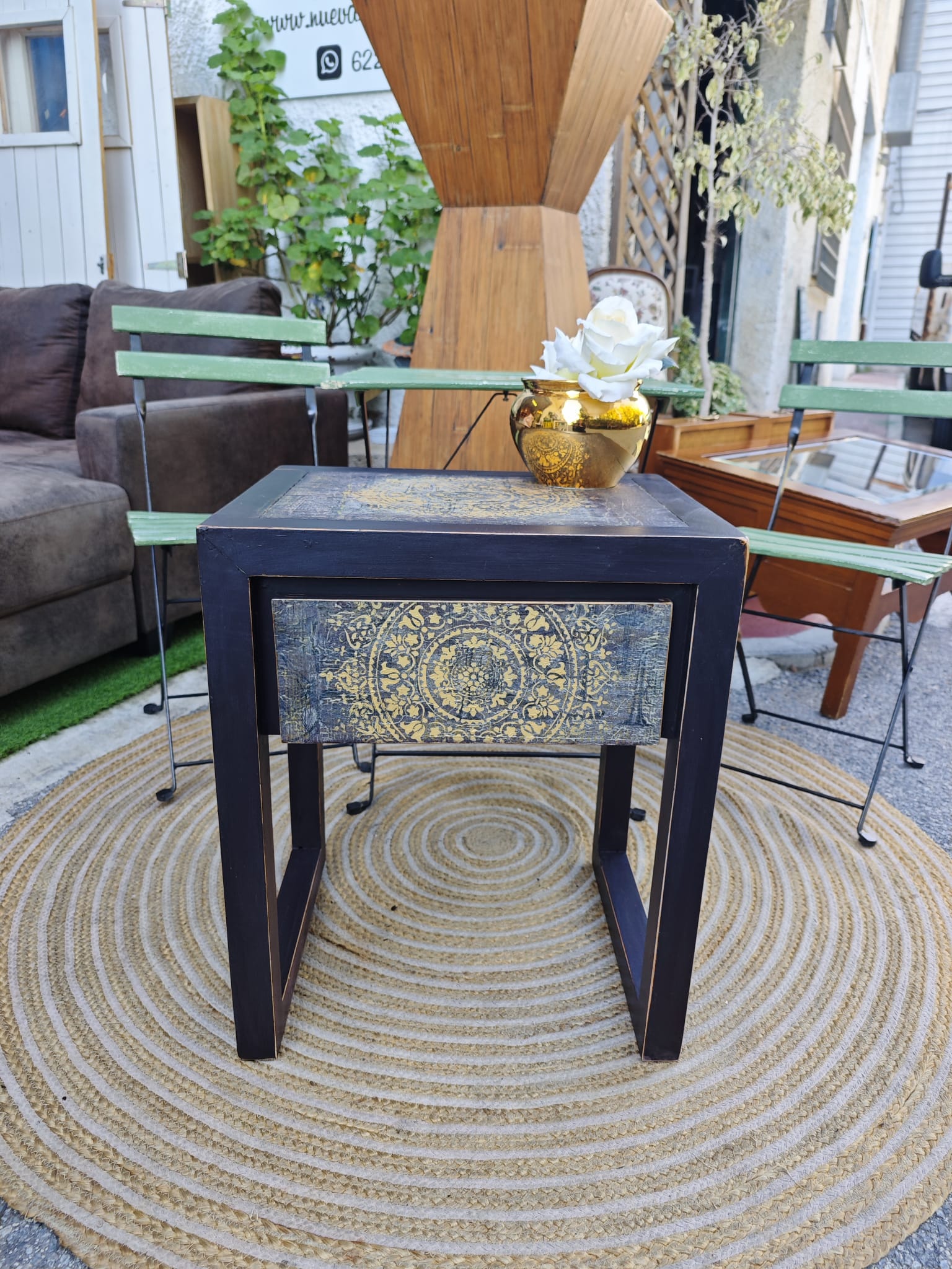 Mesita auxiliar Mandala 1 Mesita auxiliar Mandala – Mesa auxiliar decorativa en madera negra con detalles dorados pintados a mano. Medidas: 50 cm ancho × 40 cm fondo × 61 cm altura.