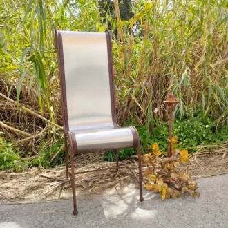Metal armchair with silver backrest and wrought iron structure.