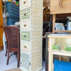 White painted wooden chest of drawers, green and mustard with diamond design. Five drawers + a open door.