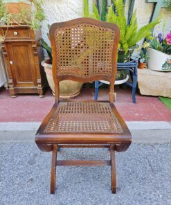 Silla vintage plegable de madera con respaldo y asiento de rejilla. Diseño clásico y funcional.