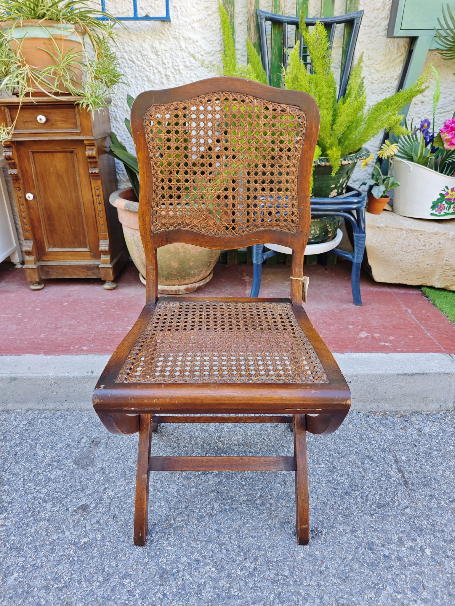 Silla vintage plegable 1 Silla vintage plegable de madera con respaldo y asiento de rejilla. Diseño clásico y funcional.