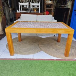 Wooden table with decorative ceramic top. Measurements: 158 cm wide, 94 cm deep, 76 cm tall. Ideal for indoors or covered spaces