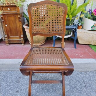 Vintage folding wooden chair with slatted backrest and seat. Classic and functional design.